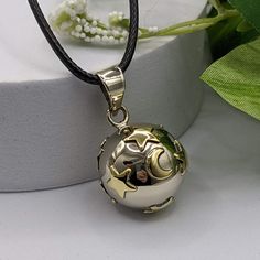 Handcrafted Orb made from Alpaca Silver, an alloy of pure silver and brass for durability. Inside the pendant is a chime; when shaken, you can hear a soft, gentle sound. Adorned with highly polished brass. The caller’s size is .78” in circumference, about the size of a US nickel; however, it will feel more substantial due to the 3D nature of the orb. Price will vary by the chain or cord you choose. Please click the drop-down selection to find the chain or cord that works best for you. Spiritual Brass Jewelry With Polished Finish, Bronze Spiritual Jewelry For Blessing, Silver Metal Meditation Jewelry, Silver Metal Jewelry For Meditation, Silver Locket Jewelry For Blessing, Silver Brass Necklace With Moon Charm, Bronze Brass Jewelry Keepsake, Silver Necklace With Moon Charm In Brass, Gold Bell Jewelry As A Gift