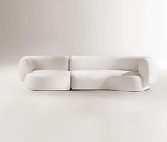 a white couch sitting on top of a white floor