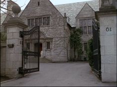 an old stone building with a gate and clock tower on the front entrance to it