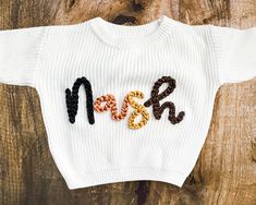 This sweater will be a staple in your tiny human's wardrobe this fall and winter! It's intentionally oversized for that perfect comfy/cozy look and feel. We currently offer a white oversized sweater in 8 different size options and 16 different yarn colors. Embroidery can be completed using one yarn color OR up to four different yarn colors to alternate between letters. These sweaters can be customized with one OR two words. Customization can include, but is not limited to, the traditional and novelty examples below! TRADITIONAL EXAMPLES: One Word: First Name Only (ie. Nash) Two Words: First & Middle Names (ie. Nash Daniel) Double Names (ie. Mary-Kate) NOVELTY EXAMPLES: One Word: Howdy Lucky (St. Patrick's Day) One (Birthday) Gobble (Thanksgiving) Two Words: Merry Christmas Big/Little Bro(t Oversized White Fall Sweater, White Comfortable Fit Sweater For Fall, Oversized White Sweater For Fall, Cozy White Sweater For Fall, White Cozy Fit Sweater For Fall, White Oversized Sweater For Fall, Oversized Embroidered White Sweater, Cozy White Fall Sweatshirt, Cozy White Cotton Sweater