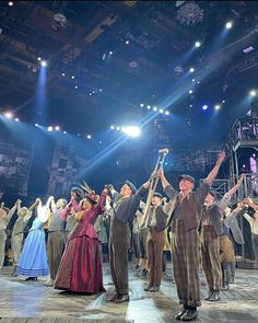 a group of people standing on top of a stage with their arms in the air