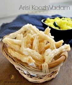 a basket filled with fries next to a bowl of mustard