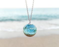 Can you imagine having a little piece of sea caressing your neck? 🌊🌊 Let me show you that little breath of nature in the form of this beach sand necklace, an ocean water necklace that is part of my Ocean theme jewelry. When you want to return to the sea, here you have this unique gift for the beach lover. When you long for the whisper of the sea, my blue resin necklace will transfer you there. When you need to know that the sea awaits you, this beach sand necklace will take you there. This daz Resin Ocean Jewelry, Water Themed Jewelry, Water Themed Accessories, Ocean Themed Accessories, Ocean Trinkets, Water Themed Outfits, Ocean Accessories, Water Necklace, Sand Jewelry