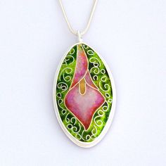 Handmade pink calla lily cloisonne enamel pendant necklace with various shades of green in the background. Set in fine silver. Sterling Silver Teardrop Jewelry With Artistic Design, Oval Enamel Jewelry For Gift, Green Teardrop Enamel Jewelry, Hand Painted Enamel Round Pendant Necklace, Enamel Necklace With Cabochon Round Pendant, Hand Painted Enamel Jewelry Gift, Enamel Cabochon Round Pendant Jewelry, Enamel Cabochon Round Pendant Necklace, Hand Painted Enamel Jewelry For Gifts