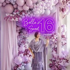 a woman standing in front of balloons with the words belia sweet 16 on it