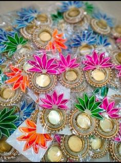 many colorful flowers are placed in plastic bags on the table, with gold coins around them