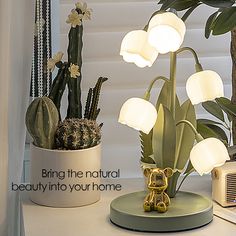 a lamp that is sitting on top of a table next to a potted plant