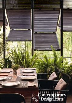 a dining room table set with plates and place settings in front of large windows that look out onto the outdoors