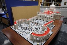 a lego model of the capital building with people standing in front of it on display