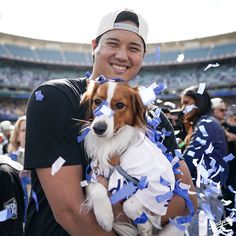 a man holding a dog at a football game