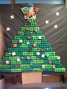 a green christmas tree made out of legos on display in front of a wall