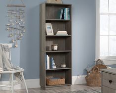 a book shelf in the corner of a room with blue walls and wooden flooring