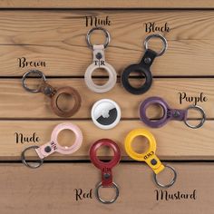 a bunch of different types of key chains on a wooden surface with names in the middle