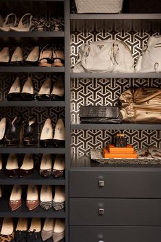 an organized closet with shoes, purses and handbags on the shelves in front of it