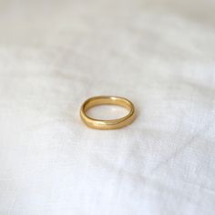 a gold ring sitting on top of a white sheet