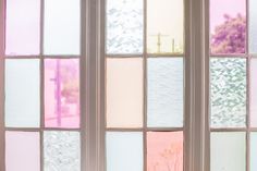 four different colored glass windows with trees in the background