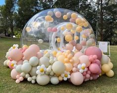 an inflatable bubble filled with lots of balloons and confetti on the ground