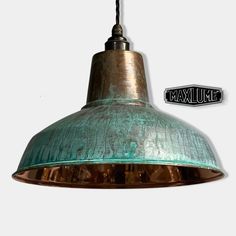 a green metal light hanging from a ceiling