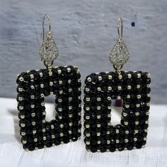 Dramatic black rectangle statement earrings with silver accents.  These beaded earrings are one of a kind, handmade, unique and real  head- turners! Made with high quality Czech facettes and permanent finish silver Japanese seed beads. Permanent finish means they don't tarnish or lose their color. Finished with a silver coloured stainless steel filigree wire earring.  Every item I design is made with the best quality beads, accessories and materials and comes in a handmade embroidered jewellery bag.  Total length: 6,5cm Length drop:  4 cm Width: 3.3 cm Depth:   8 mm Weight (per pair):  22 gr Other colour variations are available in my shop. Unique Handmade Black Earrings, Black Rectangular Beaded Jewelry, Black Beaded Evening Earrings, Unique Black Beaded Earrings, Black Handmade Earrings For Evening, Handmade Black Earrings For Evening, Handmade Black Evening Earrings, Unique Black Earrings For Evening, Handmade Elegant Square Earrings