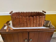 a basket sitting on top of a cabinet next to a pair of wooden spoons