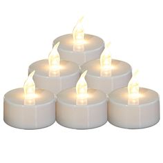 six white candles are lit up in the shape of a pyramid