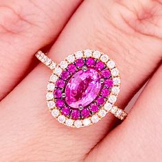 a woman's hand with a pink and white diamond ring on top of it