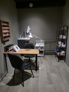 an office with a desk, chair and shelving unit in the back ground area