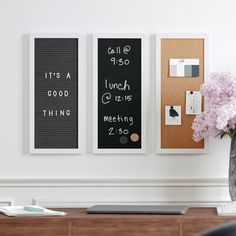 a vase filled with flowers sitting next to two framed pictures on a wall above a desk