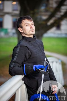 a man in black jacket holding a blue scooter