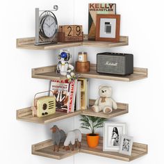 three wooden shelves with pictures, toys and other items on top of them in front of a white wall