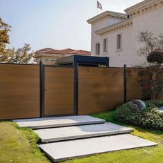 an outdoor area with steps leading up to a fenced in yard and house behind it