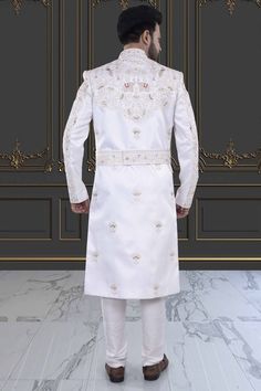 Introducing the V20-S45 Mens Sherwani, adorned with intricate peacock and elephant embroidery. This stunning white sherwani is accented with rich red details. Perfect for grooms seeking luxurious elegance on their special day. Elevate your style with this exclusive piece. Elegant Kurta With Traditional Drape For Ceremonies, Elegant Traditional Drape Kurta For Ceremonies, Elegant Embroidered Nehru Jacket For Traditional Ceremonies, Elegant Churidar With Zari Work For Traditional Ceremonies, Elegant Off White Embroidered Sherwani, Elegant Embroidered Off White Sherwani, Elegant Off-white Embroidered Sherwani, Elegant Churidar With Intricate Embroidery For Traditional Ceremonies, Elegant White Nehru Jacket For Transitional Season