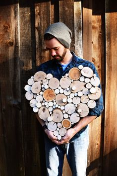 a man holding a heart made out of logs