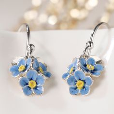 Indulge in the artistry of these handcrafted silver Forge Me Not hook dangle earrings, where meticulous attention to detail meets exquisite craftsmanship. Each earring features three enchanting blue petal flowers, delicately adorned with shimmering silver-plated accents, and two intricately sculpted leaves for added allure. The hook part is meticulously crafted from sterling silver, ensuring both comfort and durability.  The Forget-me-not flower has a timeless charm and is a symbol of eternal lo Silver Flower Jewelry With Matching Earrings, Sterling Silver Flower Earrings For Mother's Day, Sterling Silver Flower Earrings For Anniversary And Mother's Day, Mother's Day Nickel-free Sterling Silver Flower Earrings, Hypoallergenic Silver Flower Earrings For Gift, Silver Drop Flower Earrings Gift, Silver Flower Earrings For Gift, Silver Flower Pendant Jewelry With Matching Earrings, Sterling Silver Flower-shaped Jewelry With Matching Earrings