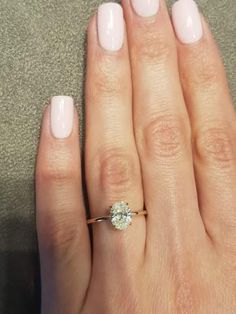 a close up of a person's hand with a ring on their finger and a diamond in the middle