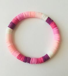 a pink, white and purple bracelet on a table