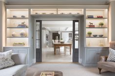 a living room filled with furniture and lots of shelves