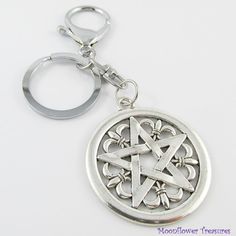 a silver keychain with a pentagramil in the center on a white background