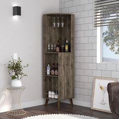 a wooden cabinet with bottles and glasses on it next to a potted plant in a living room