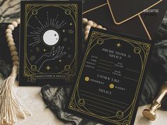 two black and gold wedding cards with the moon on them, sitting next to each other