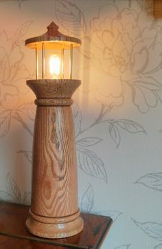 a wooden table with a lamp on it and a wallpapered background behind it