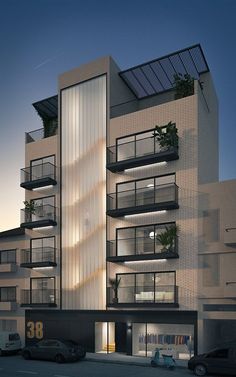 an apartment building with balconies and plants on the balconys at night time