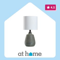 a lamp that is sitting on top of a blue and white background with the words at home below it