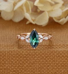 an engagement ring with a green stone and white diamonds