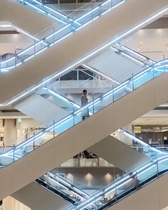 an escalator in a large building with people walking up and down the stairs