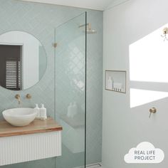 a bathroom with a sink, mirror and stand up shower stall in it's corner