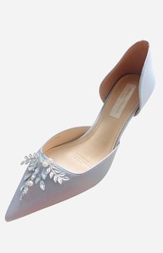 a women's shoe with flowers on the toe and heels in white leather, side view