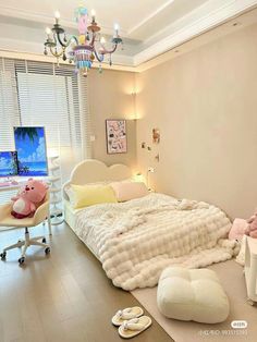 a bedroom with a large bed and chandelier