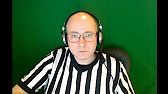 a man wearing headphones sitting in front of a green wall with a black and white striped shirt