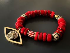 The Red Coral Evil Eye Bracelet displays a unique vibrant style and has immense spiritual and protective power. Featuring red coral stones and a large evil eye charm this bracelet is stylish and powerful to wear during meditation and daily life. The Evil Eye is a prominent symbol in Turkish and many other cultures, and is highly protective. Evil Eye is also called nazar. Evil Eye beads reflect ill intent and jealousy from the 'evil eye' back to the person thinking of it, hence protecting the wea Traditional Red Bracelets For Meditation, Red Spiritual Beaded Bracelets For Meditation, Handmade Red Symbolic Beaded Bracelets, Traditional Hand-strung Beaded Bracelets For Good Luck, Spiritual Red Coral Beads, Red Gemstone Beads Bracelets For Meditation, Red Beaded Bracelet For Meditation, Red Beaded Bracelets For Meditation, Red Spiritual Gemstone Beaded Bracelets